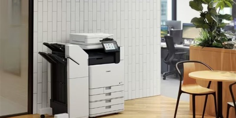 Multifuncional Canon em ambiente de escritório com plantas e mesa de reunião