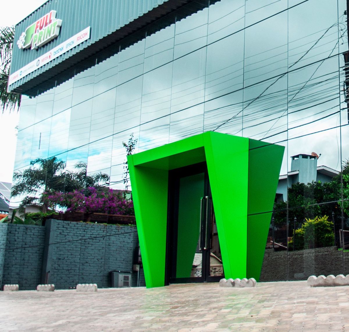 Entrada da base da FullPrint em Passo Fundo, fachada de vidro e portal verde